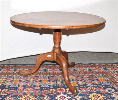 Lot 1199 - A George III mahogany circular tilt top table, 75cm by 53cm