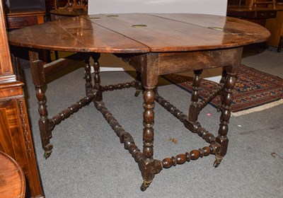 Lot 1201 - A joined oak six-to-eight-seater gateleg dining table, circa 1720, with oval drop leaves above...