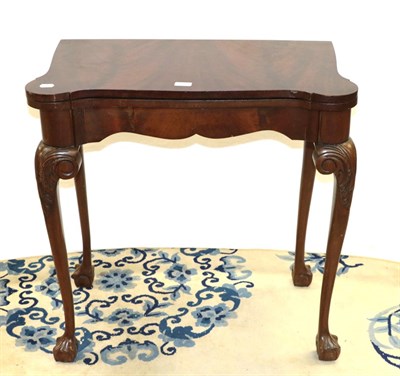 Lot 1237 - An early 20th century mahogany fold over card table on ball and claw feet