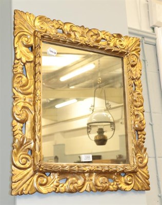 Lot 1288 - A gilt framed mirror decorated with scrolling leaves, 52cm by 58cm