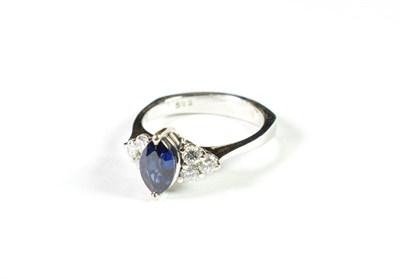Lot 195 - A sapphire and diamond ring, the marquise cut sapphire flanked by trios of round brilliant cut...