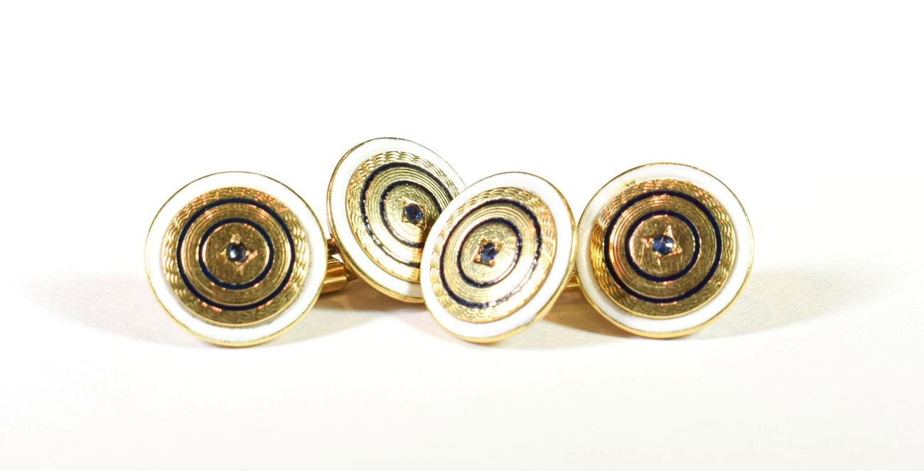 Lot 204 - A pair of enamel cufflinks, the chain linked yellow textured circular plaques with a blue stone...