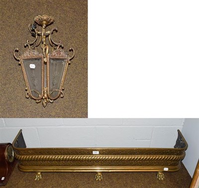 Lot 403 - A hanging light fitting of lantern form and a Victorian brass fire fender, 120cm wide, 32cm deep