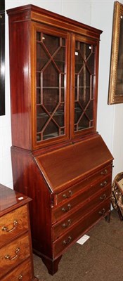 Lot 1166 - An Edwardian mahogany and satinwood banded bureau bookcase with geometric astragal glazed doors and