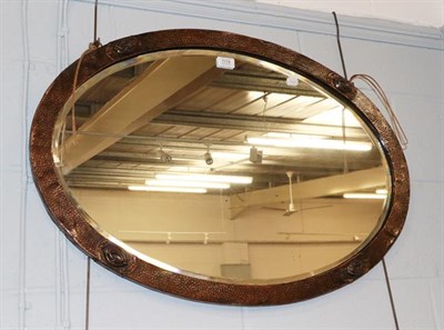 Lot 1174 - An Arts & Crafts oval planished copper wall mirror, 83cm by 58cm