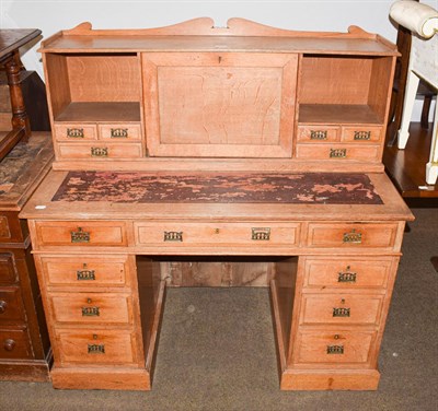 Lot 1205 - An early 20th century light oak twin-pedestal leather topped desk with raised super structure,...