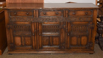 Lot 1215 - A 17th century style carved oak dresser base with three drawers and panelled cupboards, 168cm...