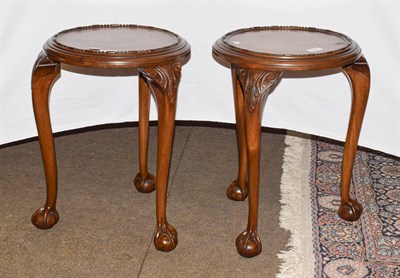 Lot 1216 - A pair of early 20th century carved mahogany plant stands, raised on carved cabriole supports...