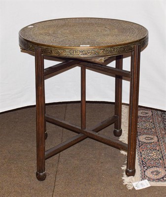 Lot 1217 - A brass ''Cairo'' table with asymmetric design with kufic script, on a folding stand, flips to...