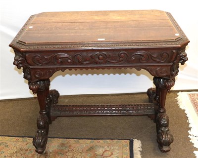 Lot 1265 - A Victorian oak Gothic-revival window table of cantered rectangular form carved with lion masks and
