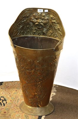 Lot 1268 - A stamped brass umbrella stand decorated with masks and shell motifs, 81cm high