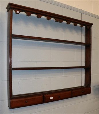 Lot 1301 - A Georgian oak three-tier dresser rack incorporating three drawers, 130cm by 15cm by 114cm