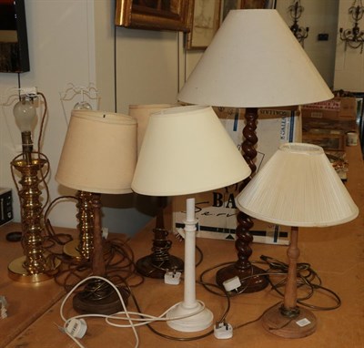 Lot 1331 - A pair of brass candlestick form table lamps, together with a pair of tapering wooden table...