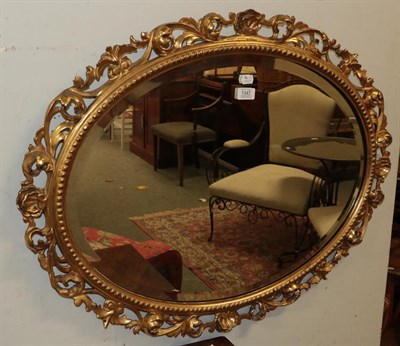 Lot 1347 - An oval bevel edged wall mirror in giltwood Florentine frame, 83cm by 65cm