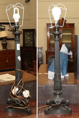 Lot 1359 - A pair of patinated metal empire style table lamps, the reeded columns on three paw feet