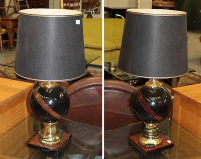 Lot 1381 - A pair of modern gloss black and burr wood table lamps of spherical form with brass fittings,...