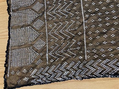 Lot 2038 - Circa 1920 Black Cotton Assuit Shawl, with geometric decoration size 73cm by 225cm; a Similar...