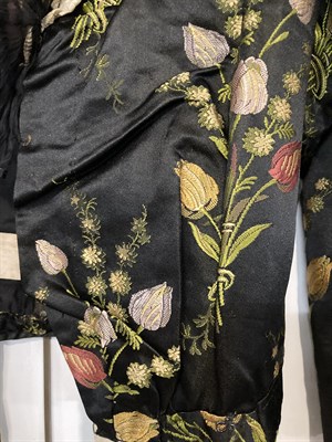 Lot 2052 - A Late 19th Century Black Silk Brocade Jacket, woven with tulips in red, yellow, and mauve,...
