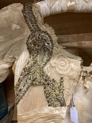 Lot 2053 - A Late 19th Century Ladies' Evening Dress, in cream silk with short net and lace pleated...