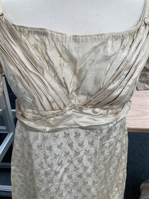 Lot 2054 - A19th Century Cream Silk Short Sleeve Dress woven with leaves, military style cream silk straps and