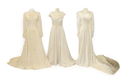 Lot 2078 - Circa 1940 and Later Wedding Dresses, comprising a cream brocade dress with a train, multi...