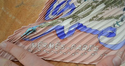 Lot 2132 - Hermès Plisse Silk Scarf Noel au 24 Faubourg, printed with the Hermès store in winter within...