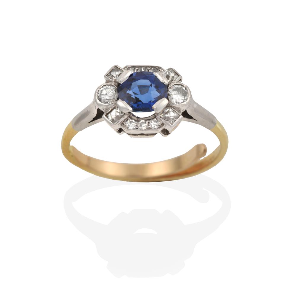 Lot 2000 - A Sapphire and Diamond Cluster Ring, the oval cut sapphire within an undulating border of eight-cut