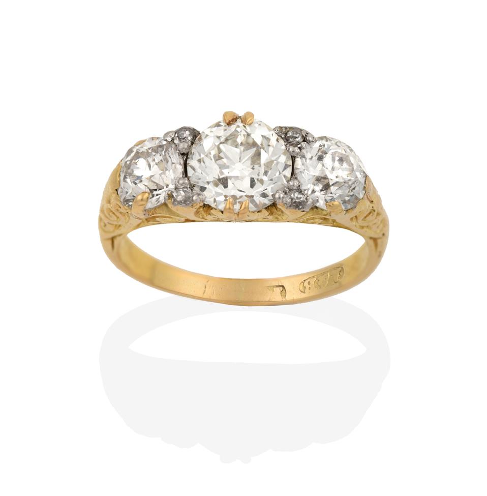 Lot 2004 - A Diamond Three Stone Ring, the graduated old cut diamonds with eight-cut diamond accents, in a...