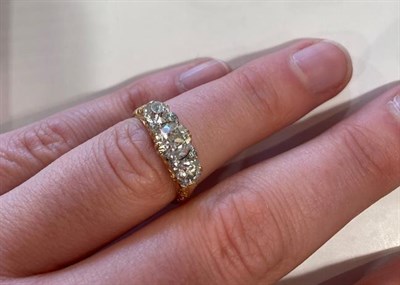 Lot 2004 - A Diamond Three Stone Ring, the graduated old cut diamonds with eight-cut diamond accents, in a...