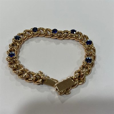 Lot 2005 - A Sapphire Bracelet, the yellow curb link bracelet with seven oval cut sapphires spaced evenly...