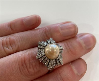 Lot 2007 - A Pearl and Diamond Cluster Ring, the central button pearl within an undulating border of eight-cut