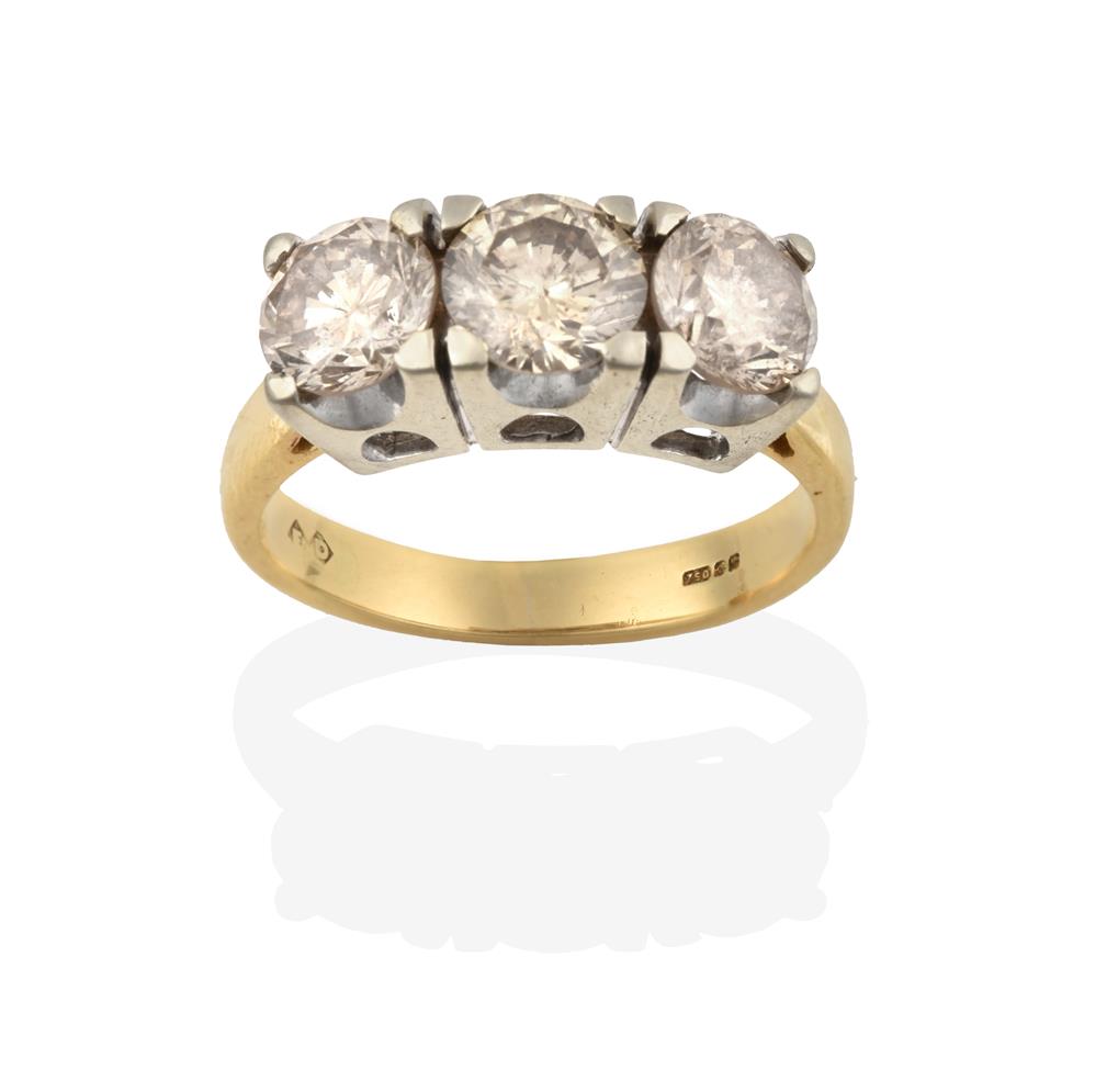 Lot 2013 - An 18 Carat Gold Diamond Three Stone Ring, the round brilliant cut diamonds in white four claw...