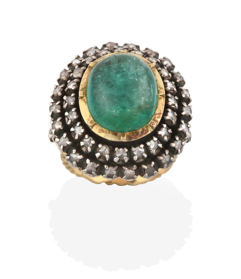 Lot 2021 - An Indian Emerald and Diamond Cluster Ring, the oval cabochon emerald in a yellow collet...
