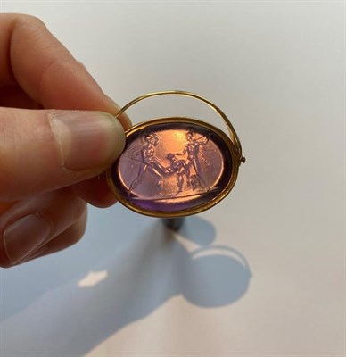Lot 2029 - An Amethyst Intaglio Swivel Fob, the oval amethyst depicting a figure subject with Roman...