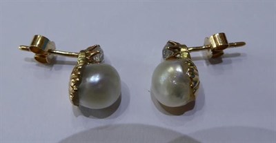 Lot 2039 - A Pair of Pearl and Diamond Earrings, an old cut diamond set above a pearl, in yellow claw...