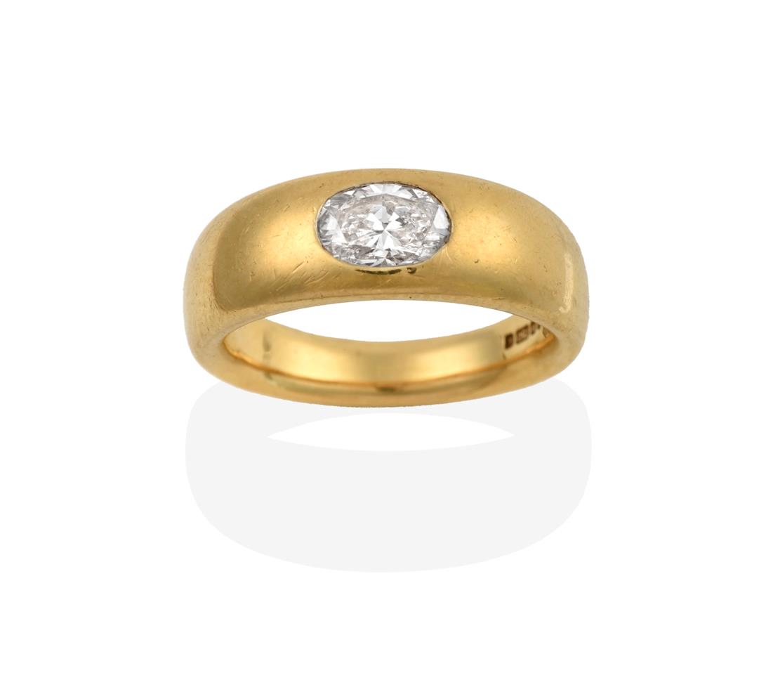 Lot 2046 - An 18 Carat Gold Diamond Solitaire Ring, an oval cut diamond inset into a yellow plain polished...