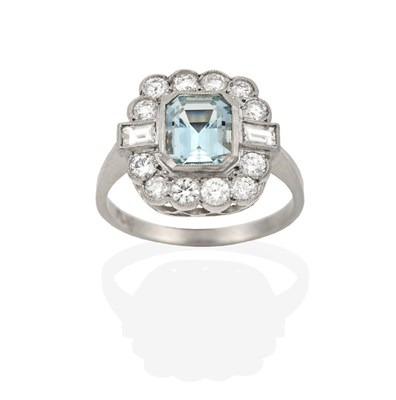 Lot 2065 - An Aquamarine and Diamond Cluster Ring, the emerald-cut aquamarine within a border of round...