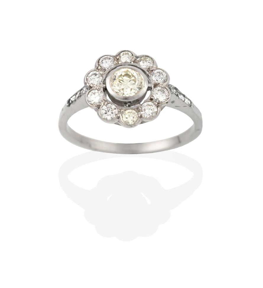 Lot 2073 - A Diamond Cluster Ring, the round brilliant cut diamond within a border of smaller round...