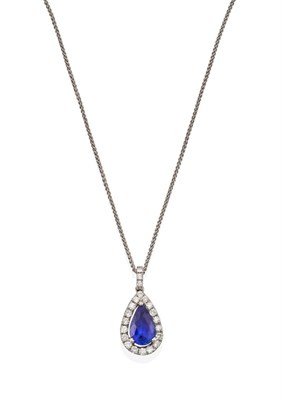 Lot 2079 - An 18 Carat White Gold Sapphire and Diamond Pendant on Chain, the pear shaped sapphire within a...
