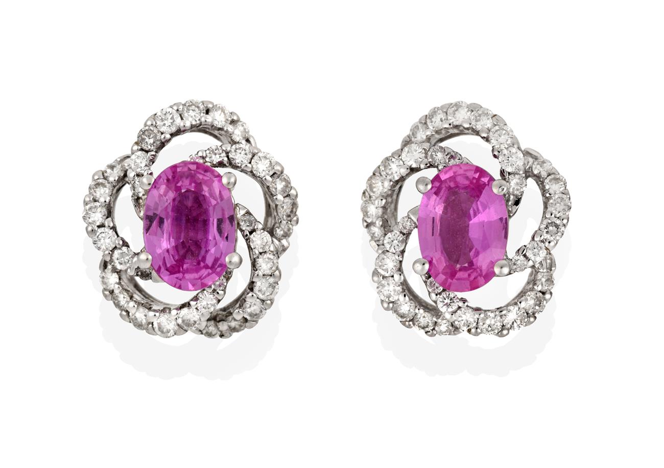 Lot 2082 - A Pair of 18 Carat White Gold Pink Sapphire and Diamond Cluster Earrings, the oval cut pink...