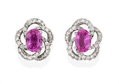 Lot 2082 - A Pair of 18 Carat White Gold Pink Sapphire and Diamond Cluster Earrings, the oval cut pink...