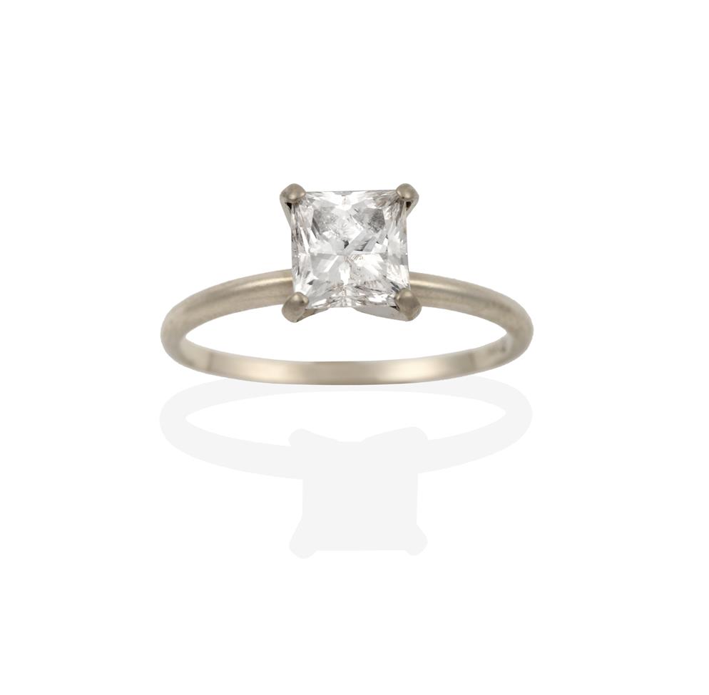 Lot 2083 - A Diamond Solitaire Ring, the princess cut diamond in a white four claw setting, to a tapered...