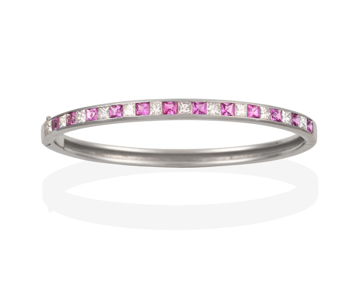 Lot 2084 - A Pink Sapphire and Diamond Bangle, princess cut diamonds alternate with square cut pink sapphires