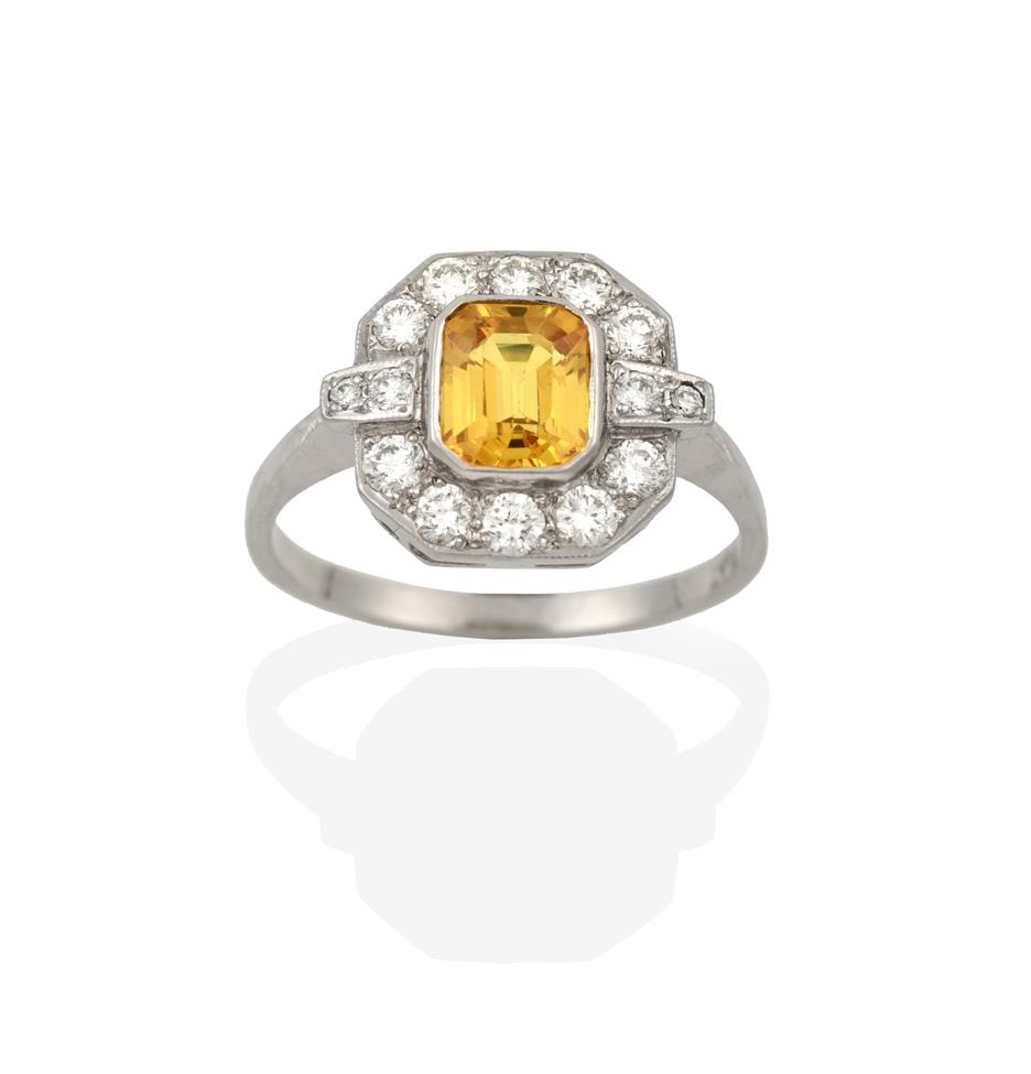 Lot 2085 - An Art Deco Style Yellow Sapphire and Diamond Ring, the central emerald-cut yellow sapphire...