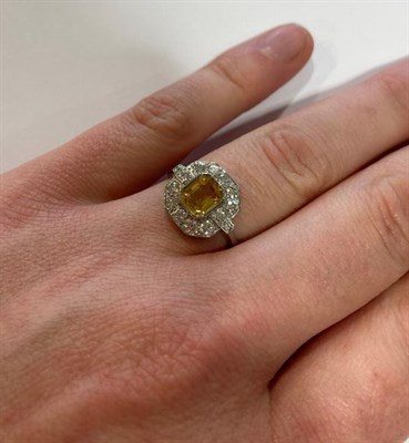 Lot 2085 - An Art Deco Style Yellow Sapphire and Diamond Ring, the central emerald-cut yellow sapphire...
