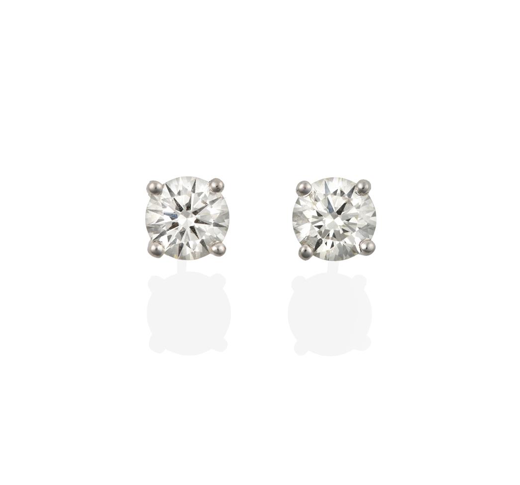 Lot 2091 - A Pair of 18 Carat White Gold Diamond Solitaire Earrings, the round brilliant cut diamonds in...