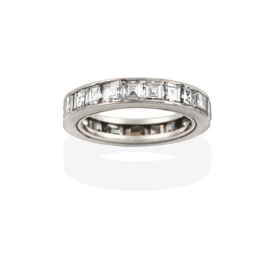 Lot 2099 - A Diamond Eternity Ring, the twenty-one square cut diamonds in a white channel setting, total...