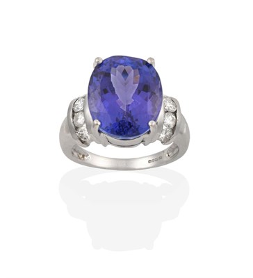 Lot 2107 - An 18 Carat White Gold Tanzanite and Diamond Ring, the oval cut tanzanite in a four claw...