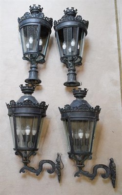 Lot 1226 - A set of four Italian patinated metal garden lanterns, 80cm with scroll cast wall mounts and...