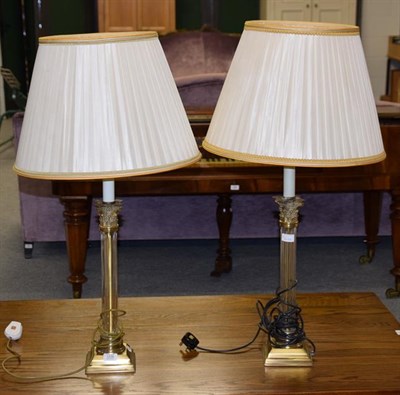 Lot 1236 - A pair of glass and gilt metal Corinthian columnar table lamps with silk shades, 62cm high